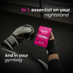 Person holding a pink 'Perform' package with boxing glovesbackground